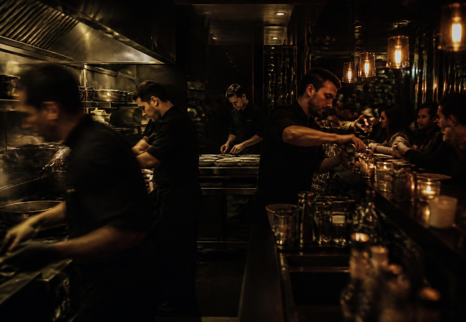 Chefs and a bartender working through a busy night service